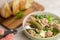 Fork holding tuna salad with blur background with bowl of salad.