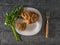 A fork next to a plate with a gyromitra mushroom on a wooden background.