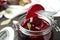 Fork with pickled beet over glass jar on table, closeup