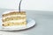 A fork pierces a piece of vanilla biscuit and buttercream cake