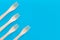 Fork setup Cutlery pattern on a bright blue background. Eco-friendly wooden disposable cutlery on bright backdrop. Wallpapers for