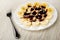 Fork, slices of banana poured chocolate sauce in plate on table