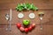 Fork,spoon,knife and smiling shaped salad vegetables on grunge wooden background
