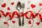 a fork and spoon surrounded by red ribbons and hearts