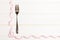 Fork surrounded with curled tape measure on wooden background with copy space. Top view of proper diet concept