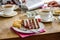 Fork on top of a piece of multi layer wedding cake with a cup of coffe on table