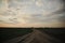 Fork of two country roads in the evening in the field. Evening landscape