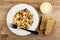 Fork, vegetable blend in plate, glass bowl with mayonnaise, slices of bread on table. Top view