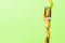 Fork wrapped in measuring tape on green background. Top view of overeating concept