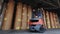 A forklift is carrying paper at the factory. The forklift is carrying a large roll of paper. Loader at the wallpaper