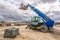 Forklift on a construction site, preparing to raise construction parts