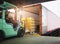 Forklift Driver Loading Package Boxes into Cargo Container. Cargo Trailer Truck Parked Loading at Dock Warehouse.