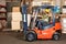 Forklift driver transports cargo in warehouse