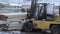 Forklift loader picks up pile of lumber boards at sawmill factory yard