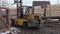 Forklift loader picks up stack of wood planks at sawmill factory court