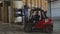 Forklift loader puts huge roll of paper on pile in storage