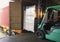 Forklift Tractor Loading Packaging Boxes into Shipping Container. Trucks Loading Dock Warehouse. Delivery Cargo Trucks Logistics