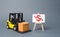 Forklift truck carries a cardboard box near a stand with a red dollar arrow down. decline in the production of goods and products