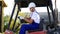 Forklift truck driver in a factory or warehouse driving between rows of shelving with stacks of boxes and packaging