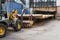 Forklift truck grabs wood in a wood processing plant. Large log loader unloading a log truck in the log yard at a