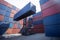 Forklift truck lifting cargo container in shipping yard or dock yard against sunrise sky for transportation import
