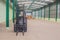 Forklifts inside empty warehouse with boxes background