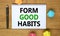 Form good habits symbol. Words `Form good habits` on beautiful wooden table, colored paper, black metallic pen. Business,