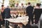 Formal clothed man hand holding tray with several glasses of white wine. Champagne with berries. Blurred guests in