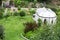 Formal garden with white gazebo, trees and flowers