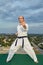 Formal karate exercises performed by adult athlete against city background