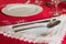 Formal table setting on red tablecloth. Luxury cutlery