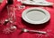 Formal table setting on red tablecloth. Luxury cutlery