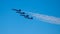 Formation of F-18 Super Hornet Blue Angel aircrafts in flight in a cloudless sky with a white trail