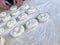 The formation of pieces of dough for pies pasties on a wooden surface floured