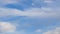 Formation and rapid movement of white clouds of different shapes in the blue sky in late spring at sunset.