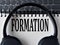 FORMATION -word on white notepad with keyboard and headphone background