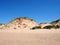 Formby beach merseyside with tall sand dunes covered in rough grass and a blue summer sunlit sky