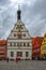 Former ancient tavern building featuring sundial astronomical clock at Marktplatz market square at rainy overcast summer day in