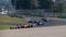 Formula cars large group battle challenging and overtaking at turn on racetrack