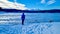 Forstsee - Rear view of man with hiking backpack watching the frozen lake Forstsee, Techelsberg, Carinthia (Kaernten), Austria,