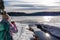 Forstsee - Woman with hiking backpack taking pictures of ducks at the frozen lake Forstsee, Techelsberg, Carinhtia