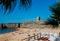 Fort in Torre beach, blue sky and ocean waves, yellow brown sand, people walking in the sand