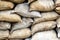 Fortification army building of sandbags. Texture of stuffed burlap retro bags. Background of dusty sackcloth