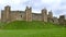 Fortified castle walls site on top of a grass hilltop