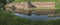 Fortress moat with water reflecting trees and castle walls. Bridge over the moat.