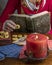 A fortune teller dressed in red reads cards and an ancient book to predict the future