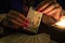 Fortune teller hands showing The Star tarot card, symbol of hope. Close-up, moody atmosphere