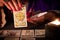 Fortune teller hands showing The Wheel of Fortune tarot card, symbol of good luck. Close-up, moody atmosphere