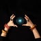 Fortune teller or witch hands and a glowing magic ball isolated on dark background. Halloween, magic and tricks concept.