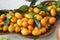 Fortunella margarita kumquats. Fresh Kumquat with leaf in wooden plate, top view